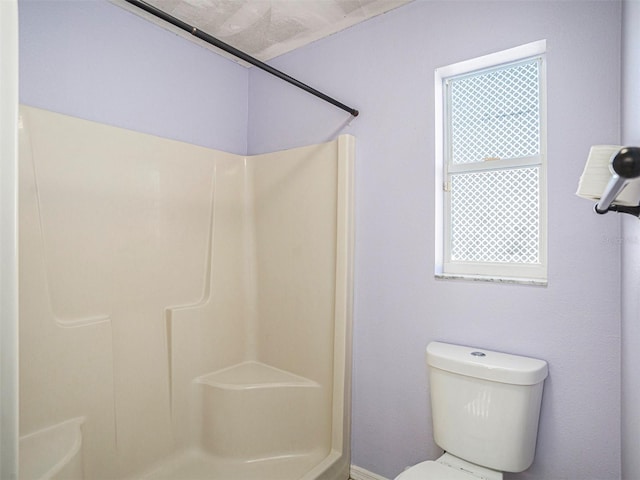 bathroom with toilet and a shower