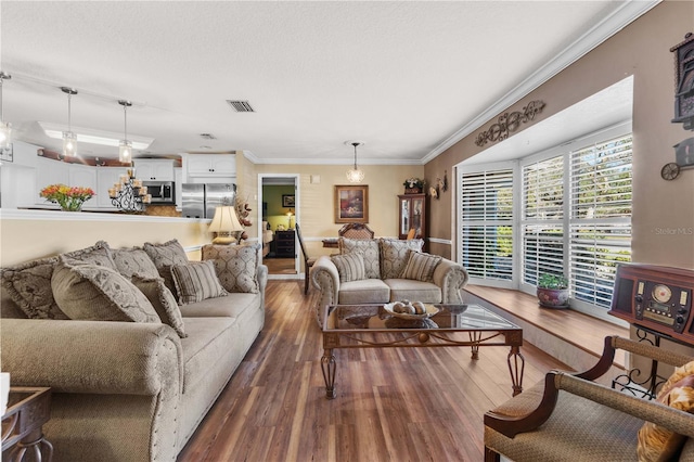 living room featuring dark wood-type flooring, ornamental molding, and a textured ceiling