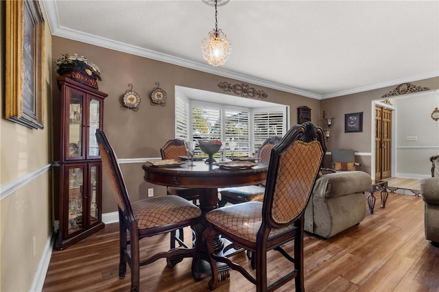 dining space with hardwood / wood-style flooring and ornamental molding