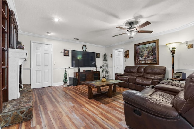 living room featuring hardwood / wood-style floors, a textured ceiling, ornamental molding, and ceiling fan