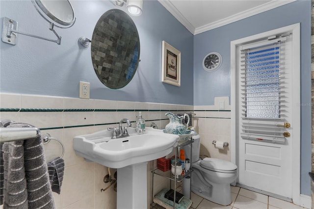 bathroom featuring sink, tile walls, ornamental molding, toilet, and tile patterned floors