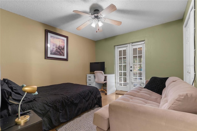 bedroom featuring french doors, ceiling fan, a textured ceiling, and access to outside