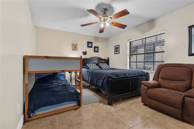 tiled bedroom featuring ceiling fan and a textured ceiling