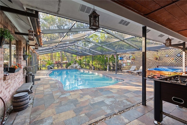 view of pool featuring a patio, glass enclosure, and a jacuzzi