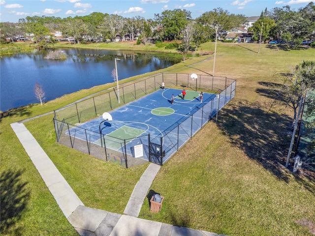 view of sport court featuring a yard and a water view