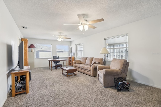 carpeted living room with ceiling fan and a textured ceiling