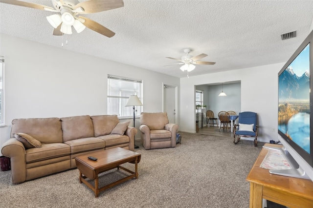 carpeted living room with a textured ceiling and ceiling fan