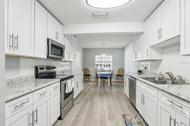 kitchen with white cabinetry, sink, and stainless steel appliances