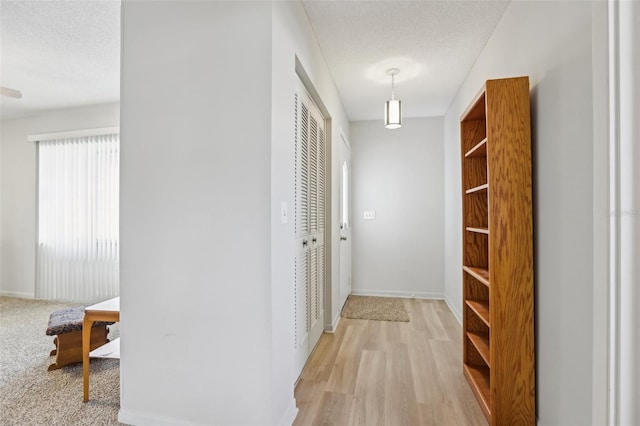 hallway with wood-type flooring and a textured ceiling