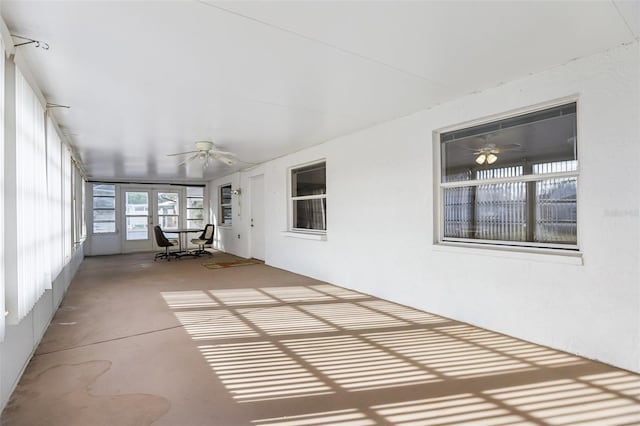 unfurnished sunroom with ceiling fan