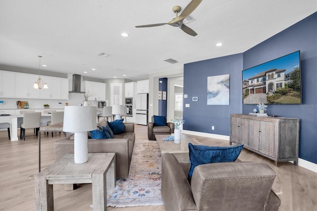 living room featuring ceiling fan and light hardwood / wood-style flooring