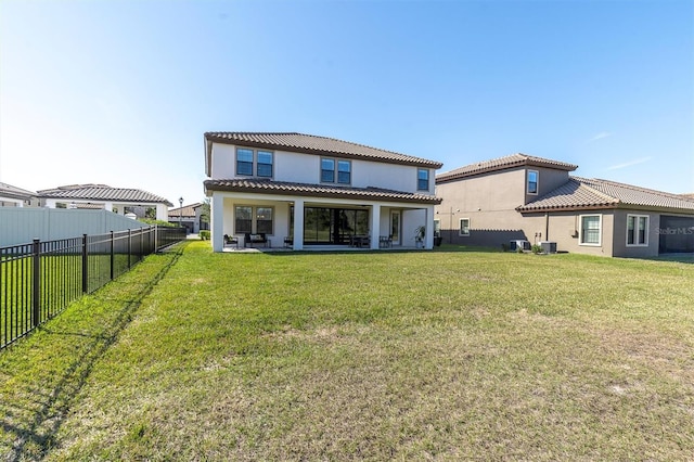 rear view of property featuring a yard, a patio area, and central AC