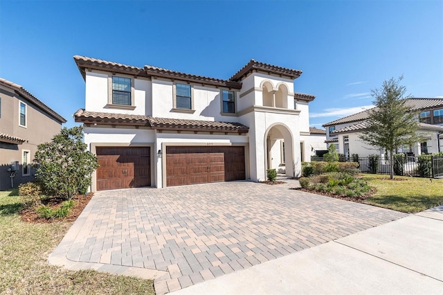 mediterranean / spanish-style house featuring a garage and a front lawn