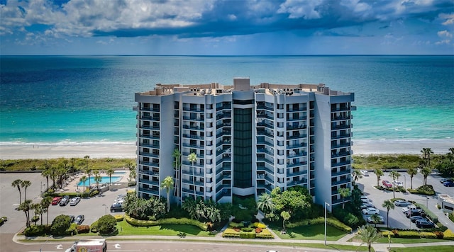 view of building exterior with a water view and a beach view