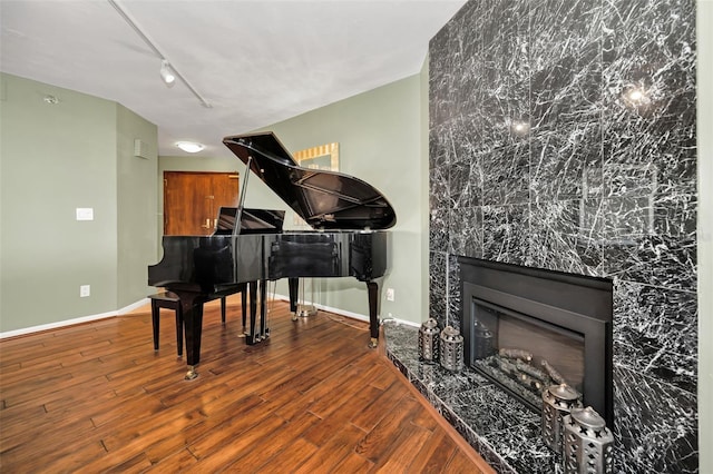 miscellaneous room featuring a fireplace, hardwood / wood-style flooring, and track lighting