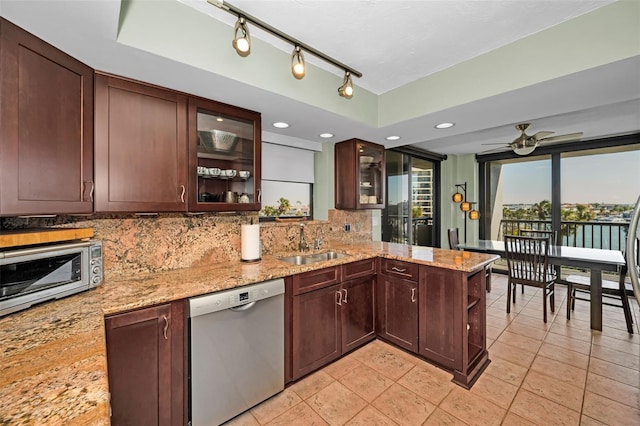 kitchen featuring light stone countertops, dishwasher, sink, and kitchen peninsula