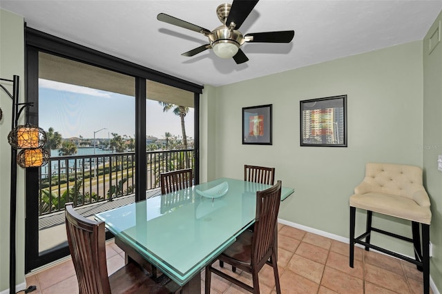 dining room with a water view and light tile patterned floors