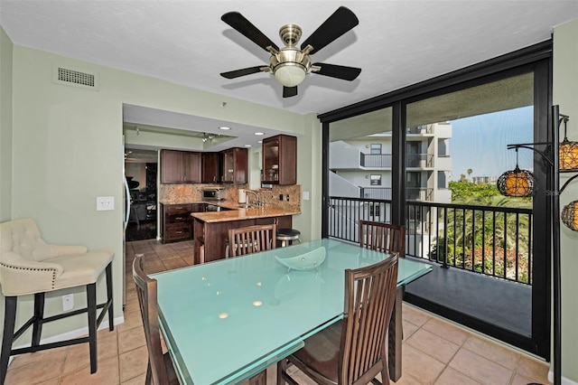 tiled dining area with sink and ceiling fan