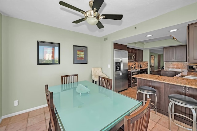 tiled dining area with sink and ceiling fan