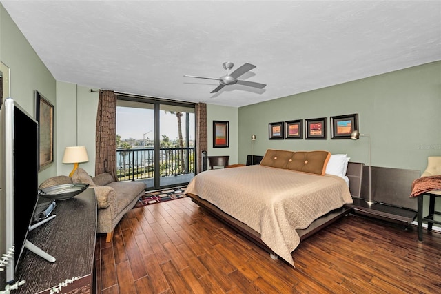 bedroom featuring a wall of windows, ceiling fan, access to exterior, dark hardwood / wood-style floors, and a textured ceiling