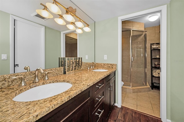 bathroom with an enclosed shower, vanity, hardwood / wood-style flooring, and toilet