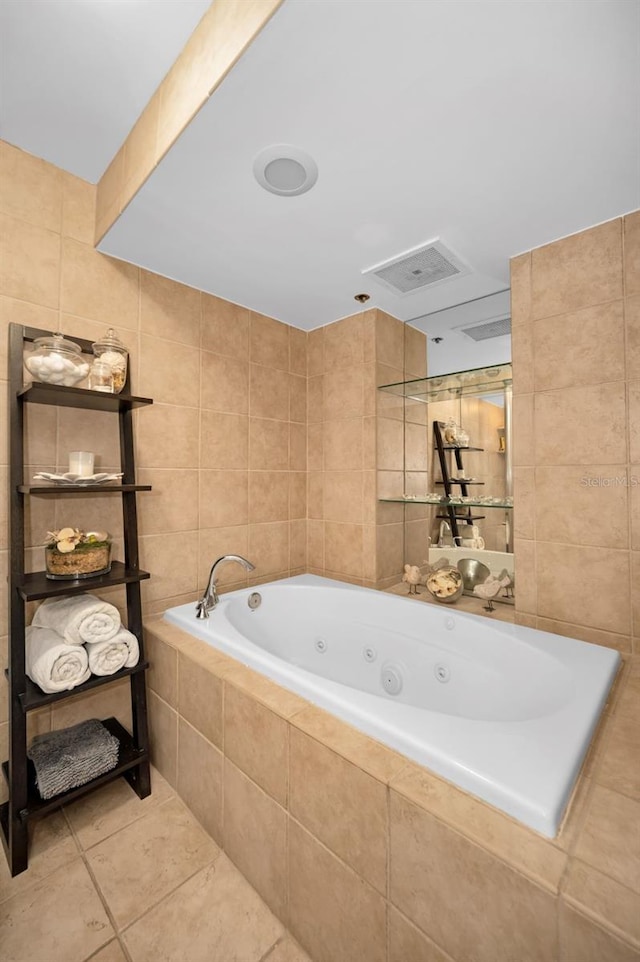 bathroom with tile patterned flooring, tiled tub, and tile walls