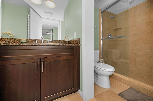 bathroom featuring vanity, toilet, a shower with shower door, and tile patterned flooring