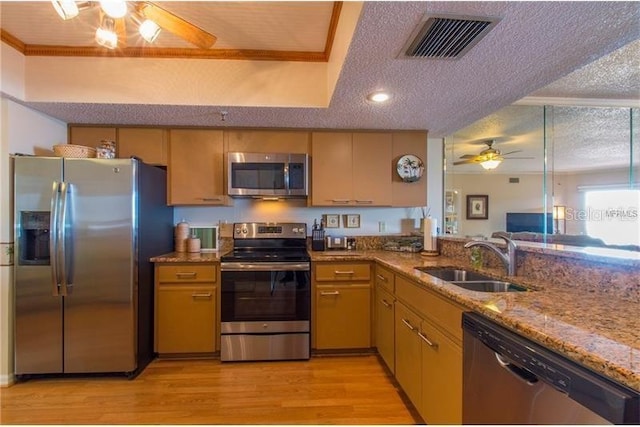 kitchen with sink, a textured ceiling, light hardwood / wood-style flooring, ceiling fan, and stainless steel appliances