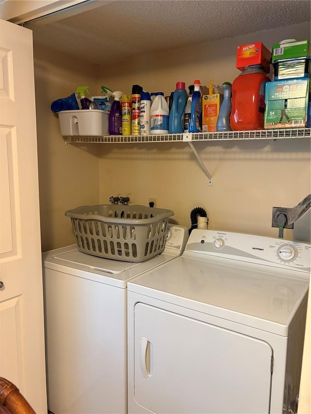 laundry area with separate washer and dryer and a textured ceiling