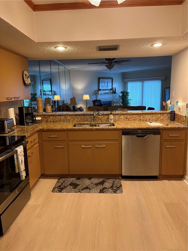 kitchen featuring stone counters, appliances with stainless steel finishes, sink, kitchen peninsula, and a textured ceiling