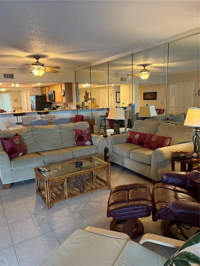 living room with ceiling fan and a textured ceiling