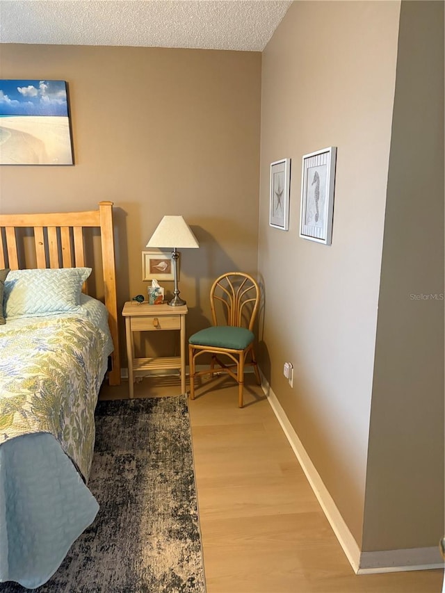 bedroom featuring hardwood / wood-style flooring and a textured ceiling