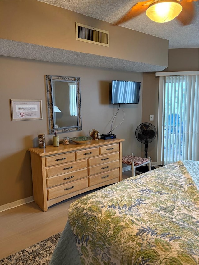 bedroom featuring a textured ceiling and light hardwood / wood-style floors