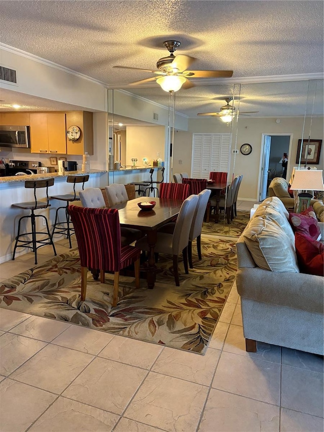 dining area with ceiling fan, ornamental molding, and a textured ceiling