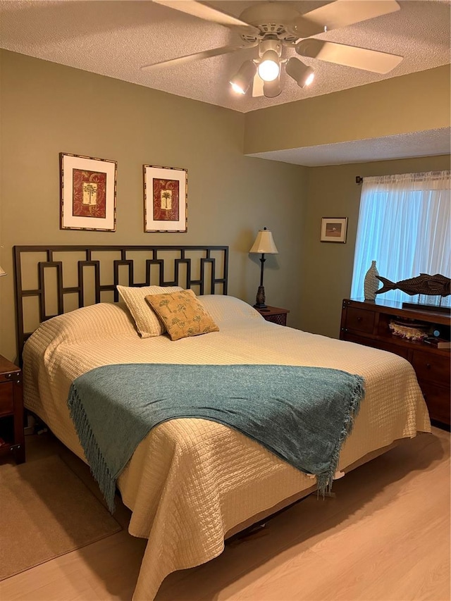 bedroom with ceiling fan and a textured ceiling