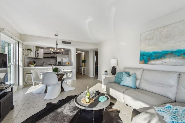 tiled living room with sink and a notable chandelier