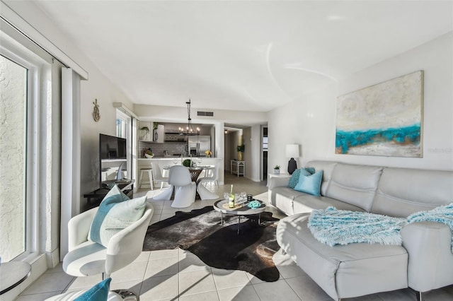 living room with a notable chandelier and light tile patterned floors