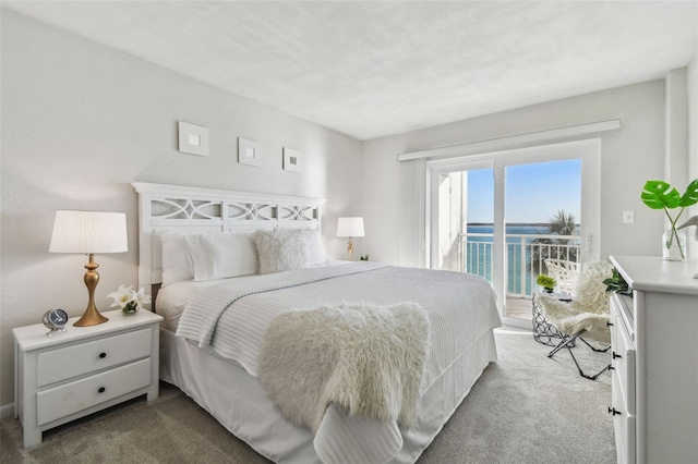 bedroom with a water view, carpet flooring, and access to exterior