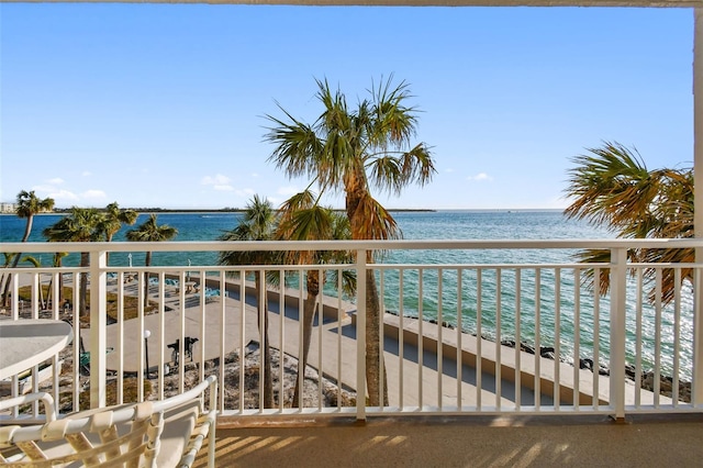 balcony with a water view and a view of the beach