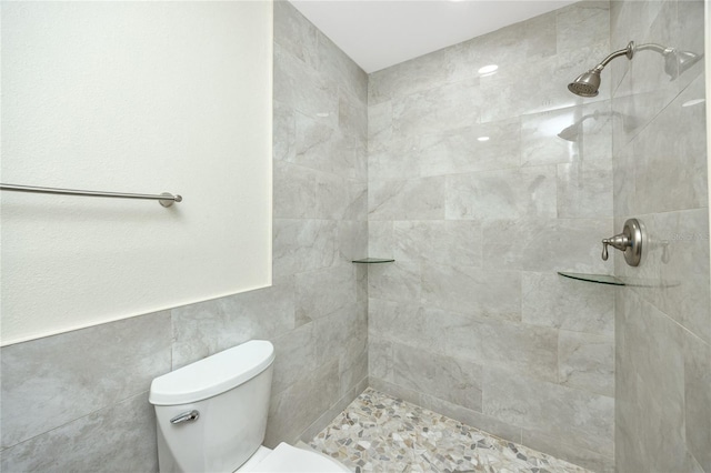 bathroom with tiled shower, tile walls, and toilet