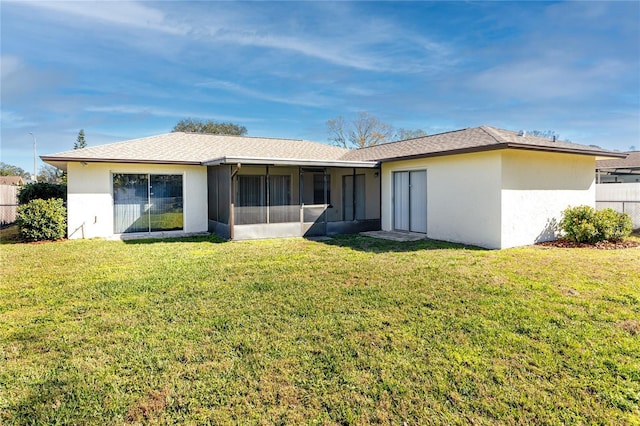 rear view of property with a lawn and a sunroom