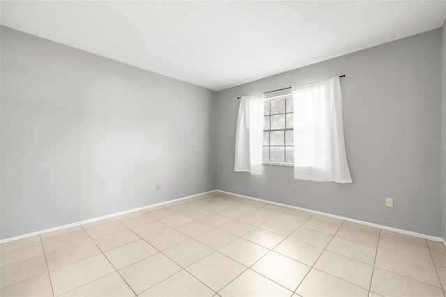 tiled spare room with a textured ceiling