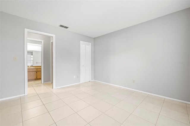 unfurnished room with light tile patterned floors and a textured ceiling