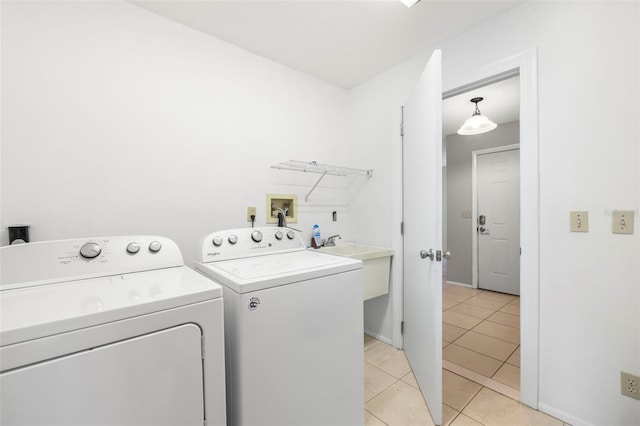 laundry area featuring sink, washer and clothes dryer, and light tile patterned flooring