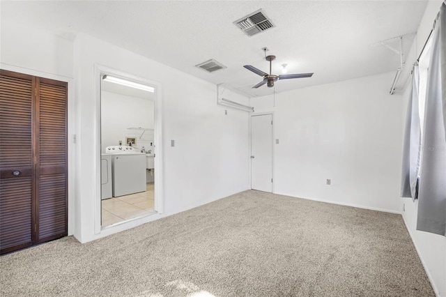 unfurnished bedroom with independent washer and dryer, ceiling fan, light colored carpet, and a closet