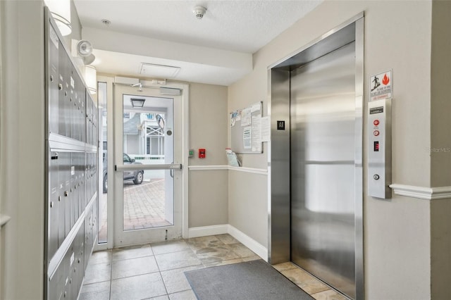 entryway featuring elevator and a textured ceiling