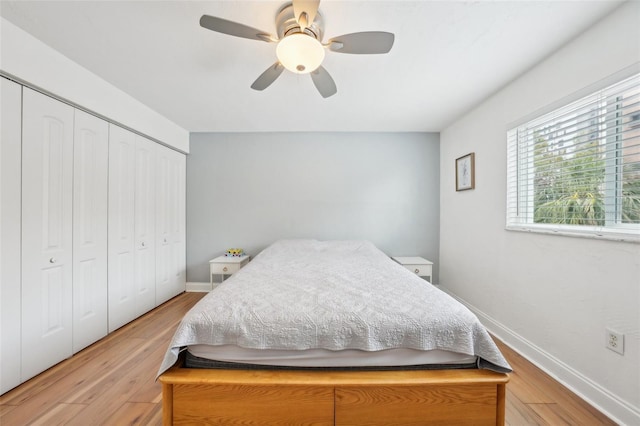 bedroom with light hardwood / wood-style floors, ceiling fan, and a closet