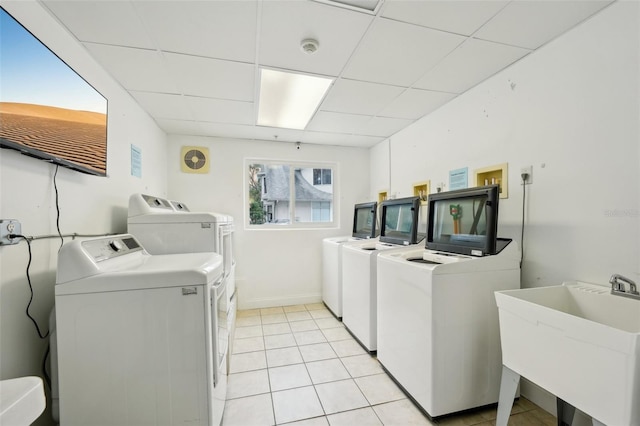 laundry room featuring sink, light tile patterned floors, and washer and clothes dryer