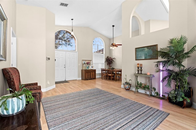 foyer featuring light hardwood / wood-style flooring, high vaulted ceiling, and ceiling fan