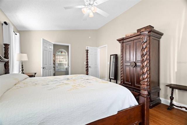 bedroom featuring ceiling fan, vaulted ceiling, hardwood / wood-style floors, and a textured ceiling